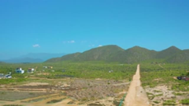 CERRITOS BCS MEXICO-2020: Muddy Long Road with Green Plants and White Building