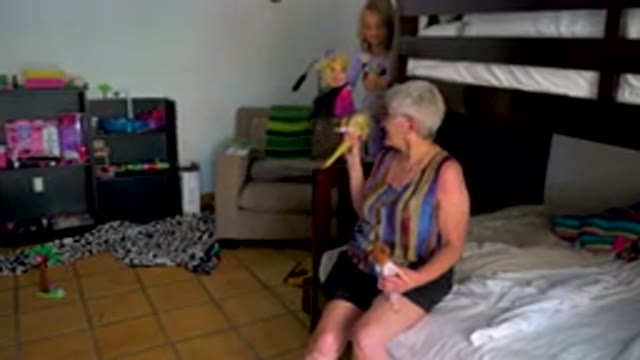 Grandmother Playing With Granddaughter In Bedroom