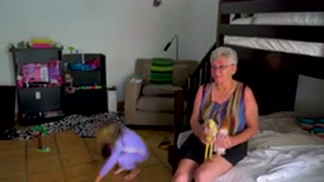 Grandmother Watching Toddler Play With Dolls