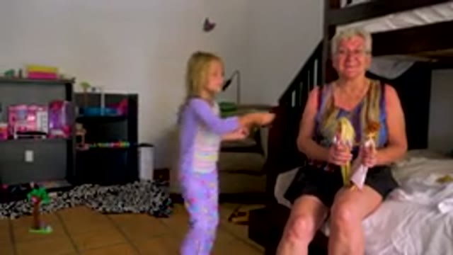 Grandmother And Granddaughter Playing With Dolls