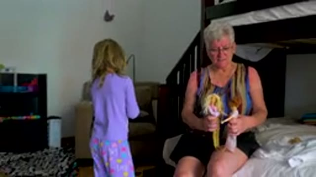 Grandmother And Granddaughter Playing With Dolls
