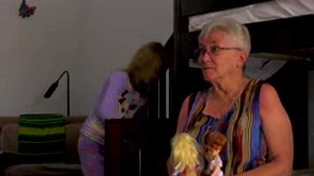 Senior Woman Playing With Dolls Indoors