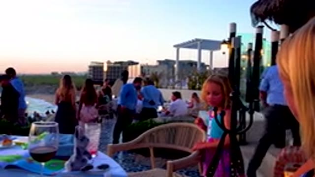 Young Girl Eating At Beachside Restaurant Patio