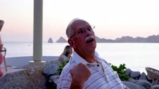 Senior Man Laughing At Beach Restaurant