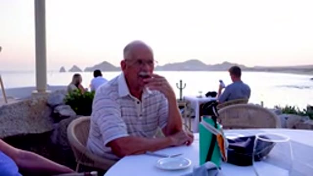 Senior Man Eating At Outdoor Restaurant