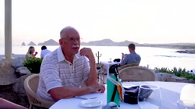 Senior Man Eating At Outdoor Restaurant