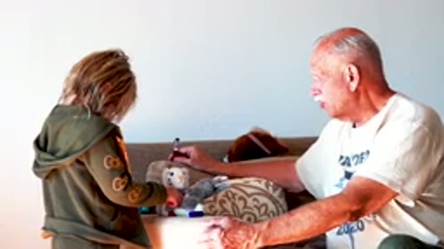 Grandfather Playing With Grandchild On Sofa