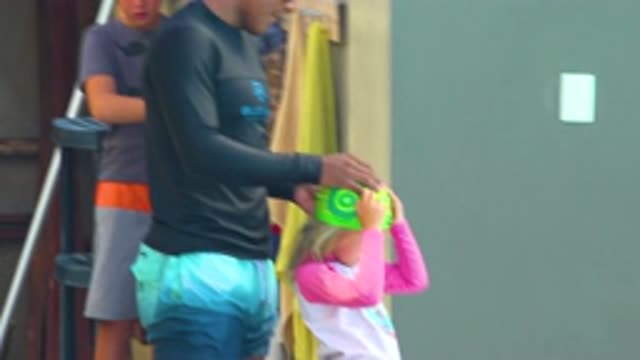 CABO SAN LUCAS MEXICO-2020: Green Small Swimming Cap Taken Off Short Kid By A Man