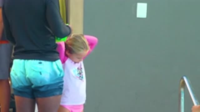 CABO SAN LUCAS MEXICO-2020: A Little Girl in Her Pink Swimsuit Doing a Ponytail