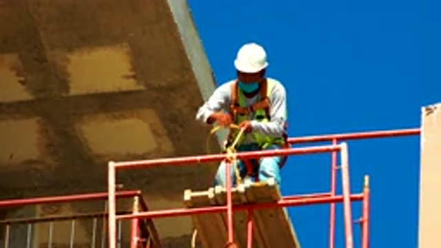 CABO SAN LUCAS MEXICO-2020: Construction Worker Bringing Up Orange Pipes