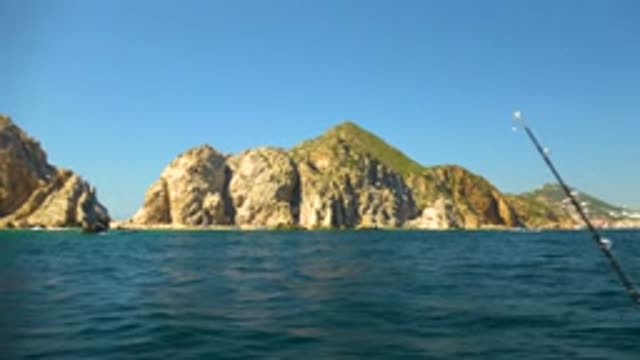 CABO SAN LUCAS MEXICO-2020: White Boat Going on Blue Sea with Small Mountains