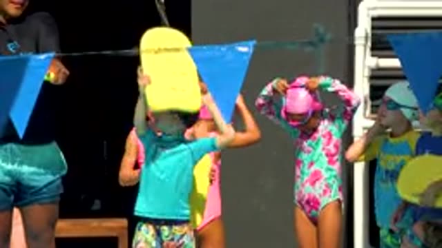 CABO SAN LUCAS MEXICO-2020: Children In Colorful Swimsuits Waving With Paddle Boards