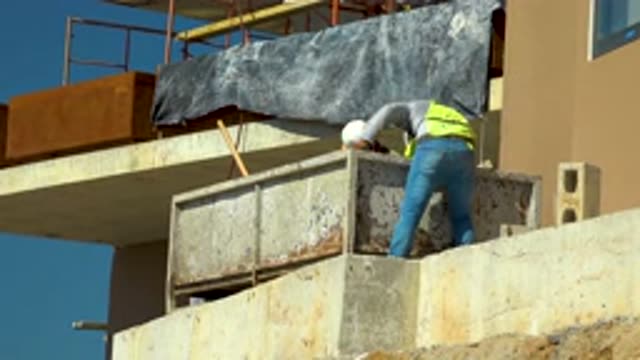 CABO SAN LUCAS MEXICO-2020: Construction Workers In Yellow Vests Dig Laboriously
