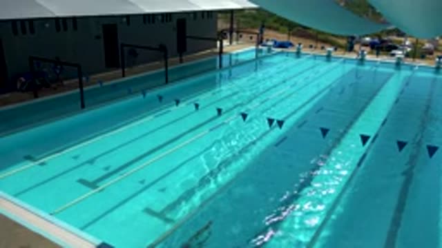 CABO SAN LUCAS MEXICO-2020: Crystal Clear Blue Swimming Pool Man With Black Suit