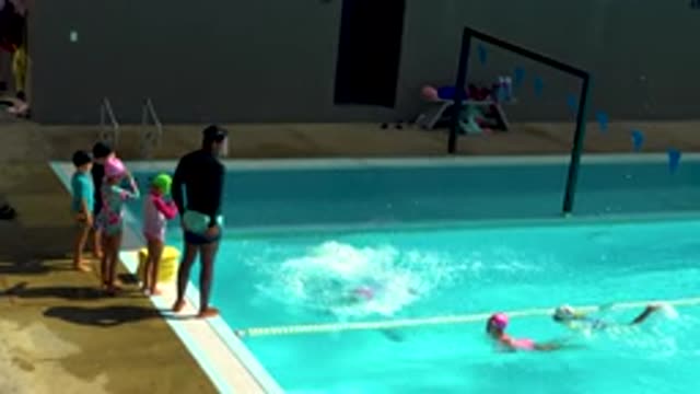 CABO SAN LUCAS MEXICO-2020: Swimming Child Jumping Into Sunlit Water With Cap And Glasses