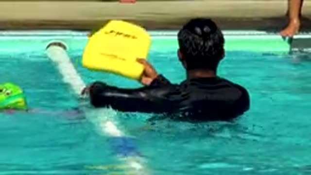 CABO SAN LUCAS MEXICO-2020: Man Handing Child a Toy to Swim in Pool