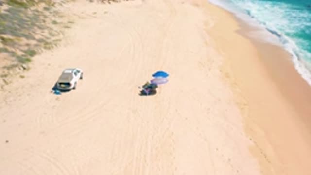 EL CARDONCITO BCS MEXICO-2020: Luxury Car on Sand Beach with Blue Umbrella and People