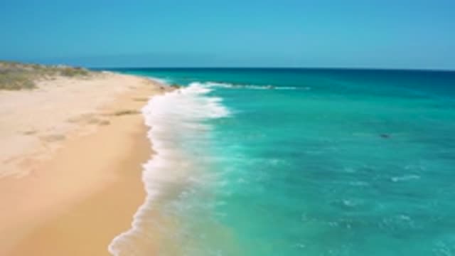 EL CARDONCITO BCS MEXICO-2020: Ocean Waves Crash On A Sandy Beach Creating White Foam