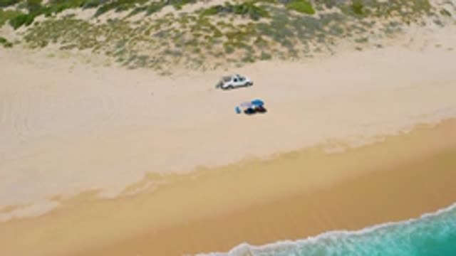 EL CARDONCITO BCS MEXICO-2020: Two People Sunbathing On Beach With Car In